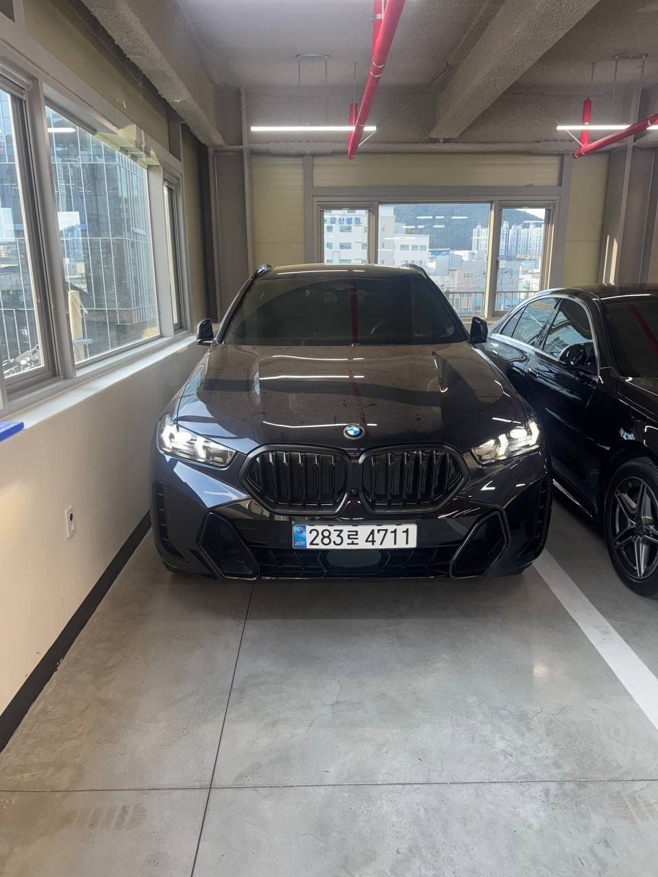 BMW X6 xDrive40i M Sport — вид спереди на парковке дилера
